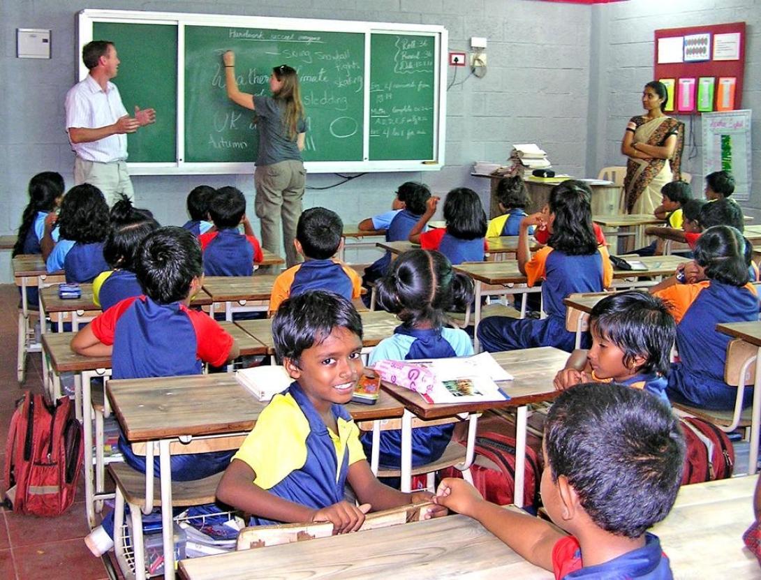 Projects Abroad English teacher writes on the blackboard during her class in India. Teaching volunteer writes down a classroom exercise during her English lesson in India.